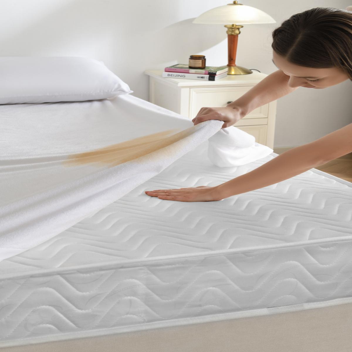 Person pouring a brown liquid onto a white mattress - Bamboo Plus Waterproof Protection.